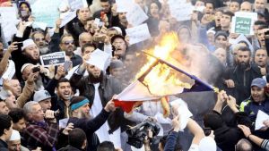 Demonstrators burn the French national flag after Friday prayers in Algiers