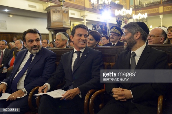 French Prime Minister Manuel Valls (C), the President of the French Jewish central Consistory, Joel Mergui (L) and France's CHief Rabbi, Haim Korsia (R) attend a ceremony at the Nazareth synagogue, as part of the presentation of the French State greetings to the French Jewish central Consistory and the Jewish community, on September 8, 2015 in Paris, ahead of Rosh Hashanah, the Jewish New Year, that falls on September 14 and 15. AFP PHOTO / BERTRAND GUAY